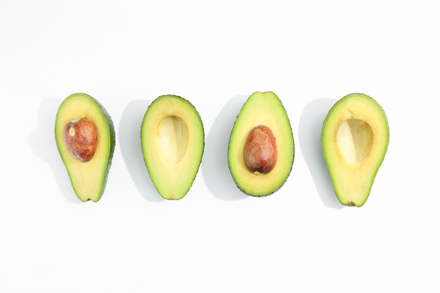 Flat lay composition with ripe avocados on white