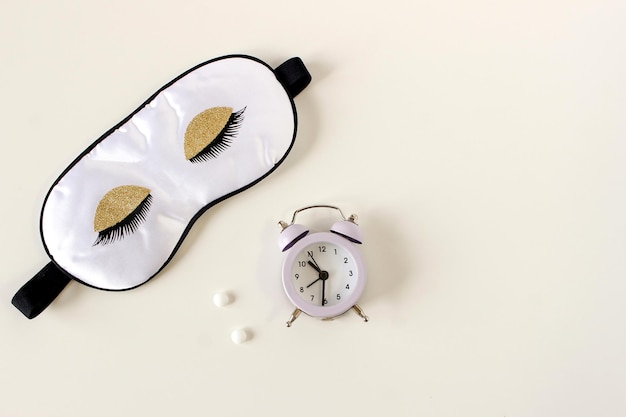 Flat lay composition with sleep eye mask dream book and alarm clock on background Healthy sleeping concept