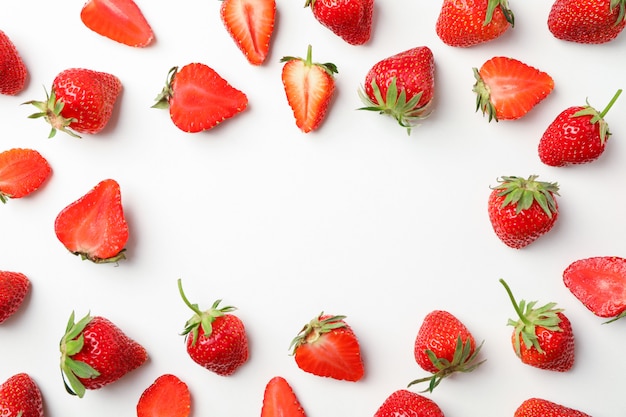 Flat lay composition with strawberries on white background, space for text. Summer sweet fruits and berries