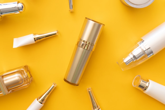 Flat lay of cosmetic products set on yellow background