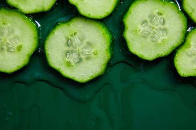 Flat lay cucumber slices with gel on green background