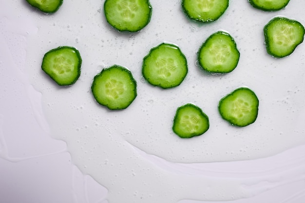 Flat lay cucumber slices with gel on white background