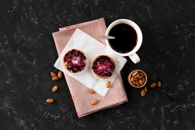 Flat lay cup with hot coffee, sweet cake on a black table, home cooked breakfasts