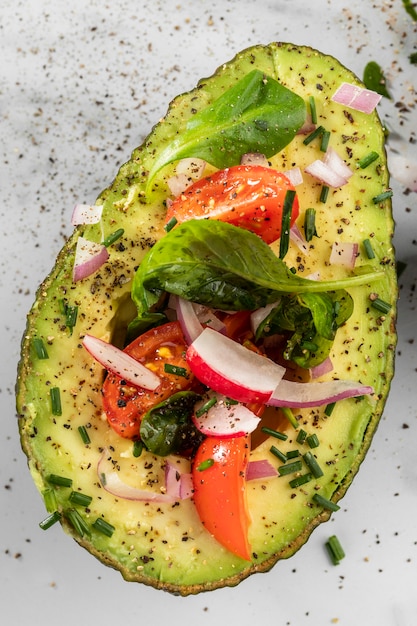 Flat lay delicious healthy salad in avocado composition