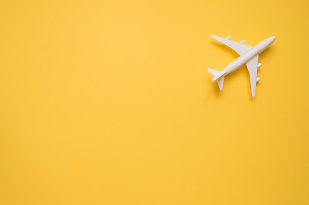 Flat lay design of travel concept with plane on yellow 