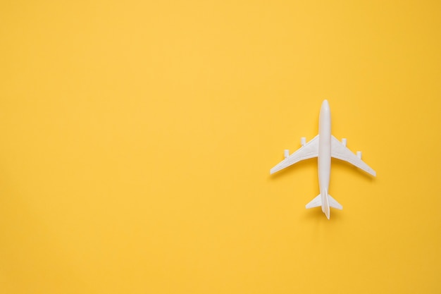 Flat lay design of travel concept with plane on yellow 