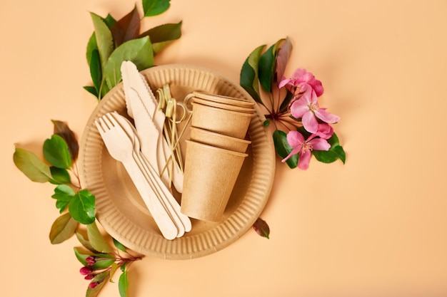 Flat lay of eco craft paper tableware with flowers Zero waste plastic free