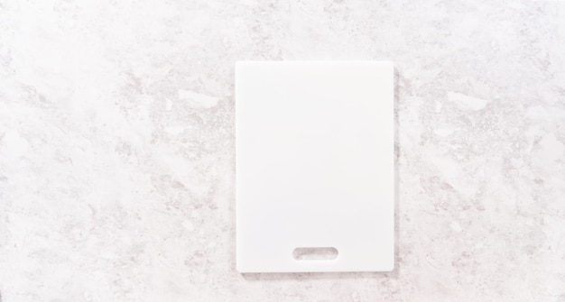 Flat lay. Empty white cutting board on the kitchen counter.