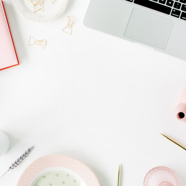 Flat lay fashion feminine home office workspace. Laptop, pink teapot, diary, coffee, golden pen and clips