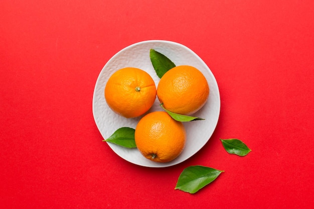 Flat lay of Fresh orange fruit with sliced in plate on Colored background Top view with copy space