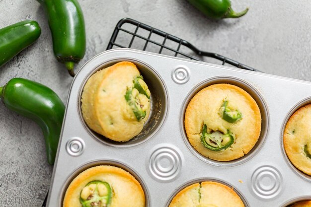 Photo flat lay. freshly baked cornbread muffins with spicy jalapeno pepper in muffin pan.