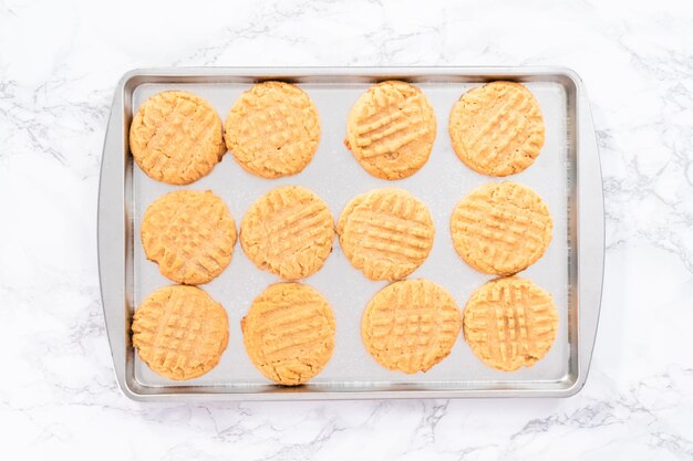 Flat lay. Freshly baked peanut butter cookies on a baking sheet.