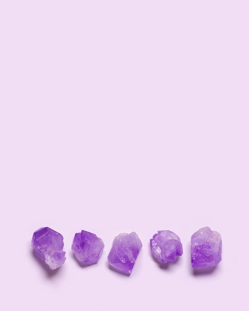 Flat lay from purple amethyst crystal on violet color background natural gemstone stacked in row