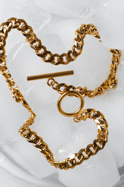 Flat lay gold chain on ice cubes