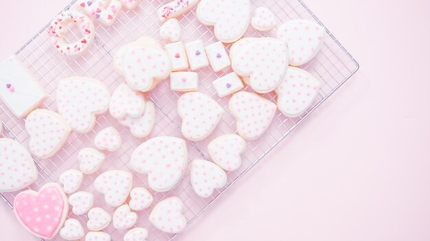 Flat lay. Heart shaped sugar cookies decorated with royal icing on drying rack.