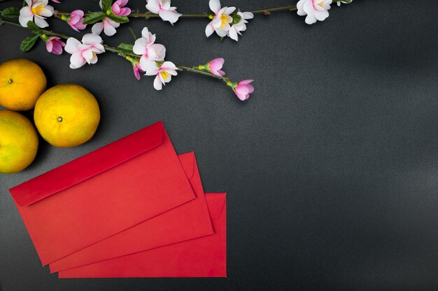 Flat lay holiday of Chinese new year red packet and of accessories blossom on top 