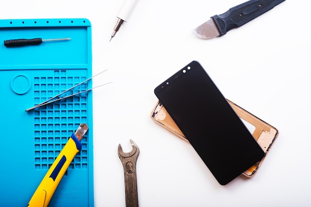 Flat lay image of dismantling the broken smart phone for preparing to repair or replace some components Top view