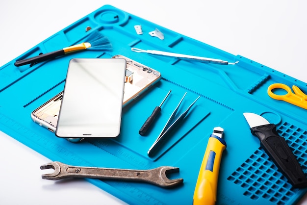 Flat lay image of dismantling the broken smart phone for preparing to repair or replace some components Top view