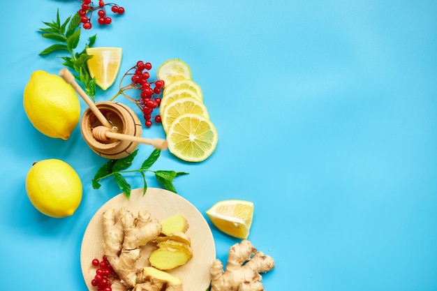 Flat lay of Immune boosting remedy immunity boosting foods ginger lemon honey guelder rose mint on blue background Top view copy spacexA