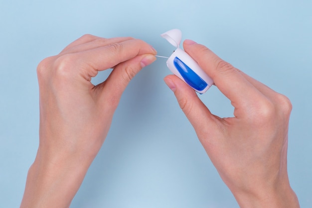 Flat lay of lady hands with dental floss isolated