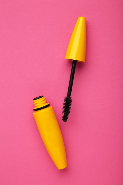 Flat lay mascara on pink background Space for text Vertical photo