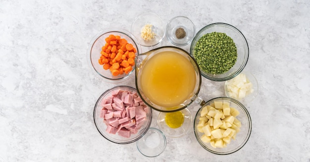 Flat lay. Measured ingredients in glass mixing bowls to make split pea soup.