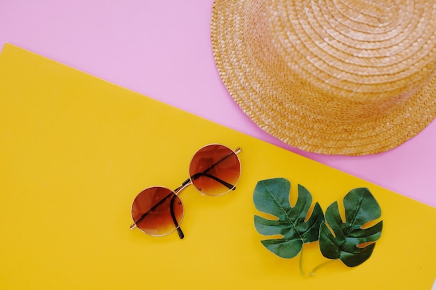 Flat lay of minimal accessories items for summer on colorful background.