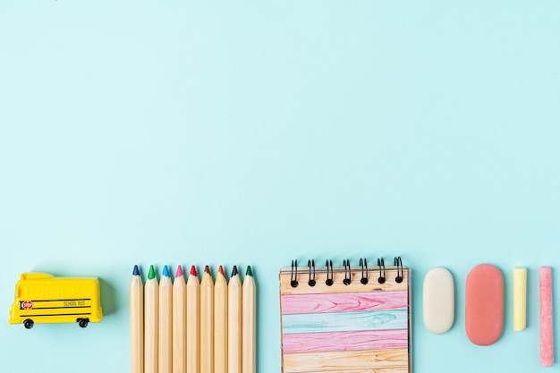 Flat lay of modern bright blue office desktop with school supplies