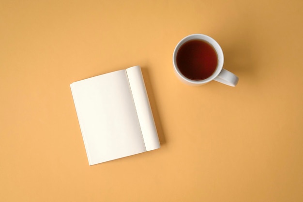 Flat lay of notepad and coffee on yellow tabletop