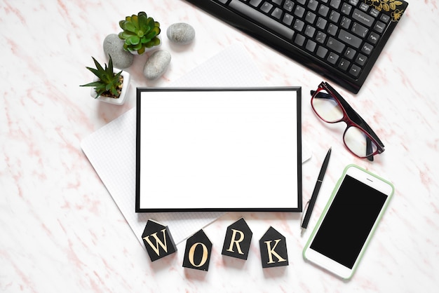 Flat lay office marble desk with phone, keyboard and notebook, frame for text space background