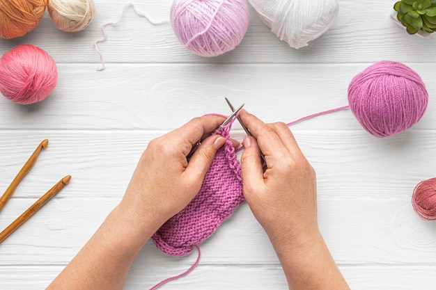 Photo flat lay of person knitting with yarn