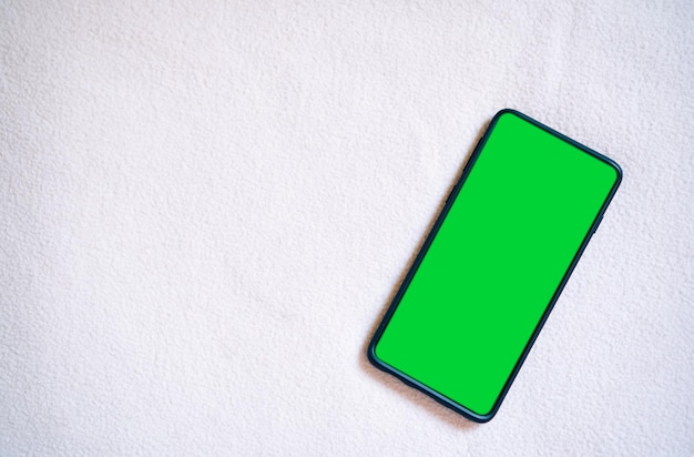 Flat lay photo of smartphone green screen Chroma key phone screen in vertical position