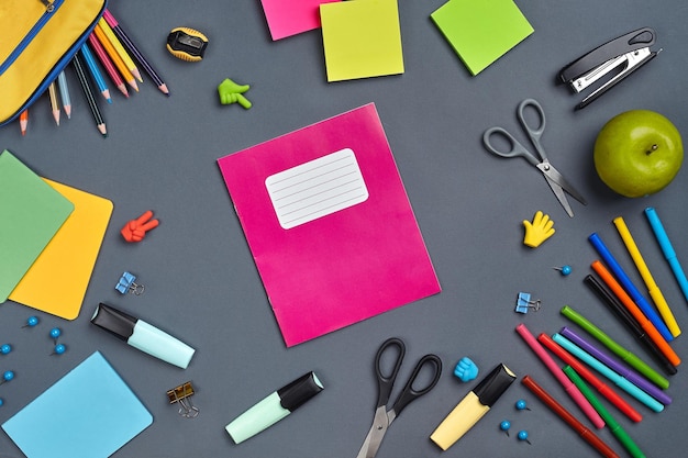 Flat lay photo of workspace desk with school accessories or office supplies on gray background