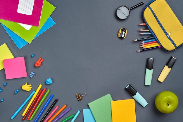 Flat lay photo of workspace desk with school accessories or office supplies on gray background