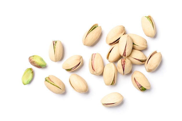 Flat lay of pistachio nuts on a white surface