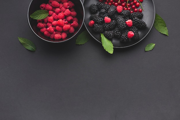 Flat-lay plate and bowl of fresh berries with copyspace