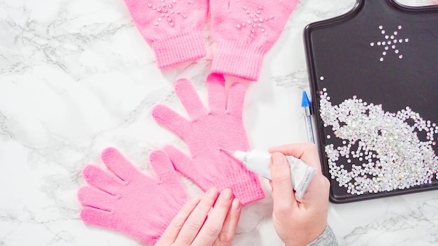 Flat lay. Rhinestone pink kids gloves with snowflake shapes.