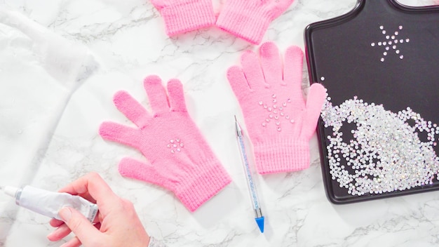 Flat lay. Rhinestone pink kids gloves with snowflake shapes.