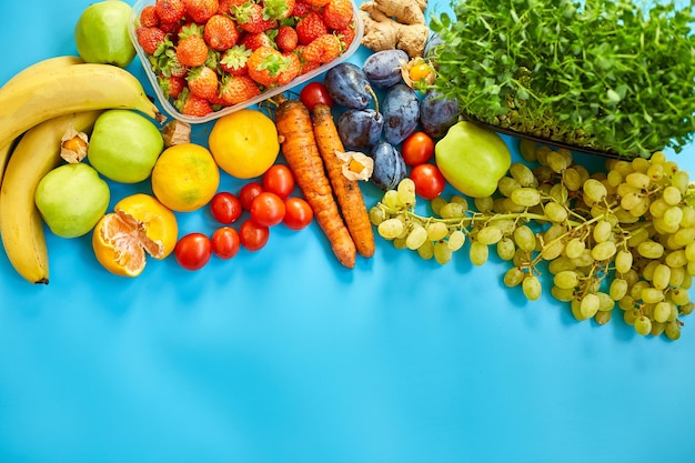 Flat lay of ripe organic healthy food Fruits microgreens vegetables on blue background copy space for text top view market local farm concept harvest food delivary diet vegan concept