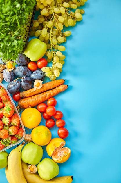 Flat lay of ripe organic healthy food Fruits microgreens vegetables on blue background copy space for text top view market local farm concept harvest food delivary diet vegan concept