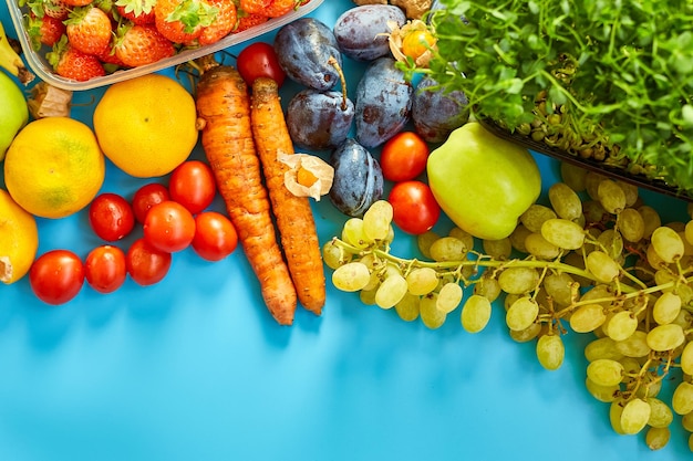 Flat lay of ripe organic healthy food Fruits microgreens vegetables on blue background copy space for text top view market local farm concept harvest food delivary diet vegan concept