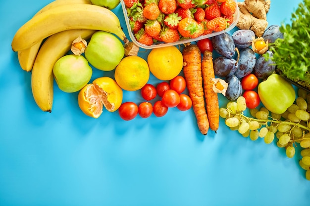 Flat lay of ripe organic healthy food Fruits microgreens vegetables on blue background copy space for text top view market local farm concept harvest food delivary diet vegan concept