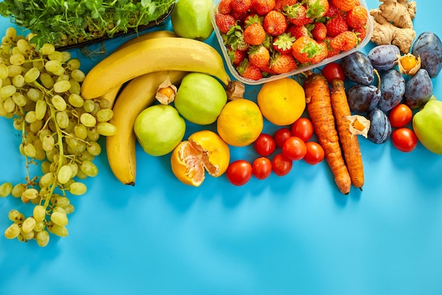 Flat lay of ripe organic healthy food Fruits microgreens vegetables on blue background copy space for text top view market local farm concept harvest food delivary diet vegan concept