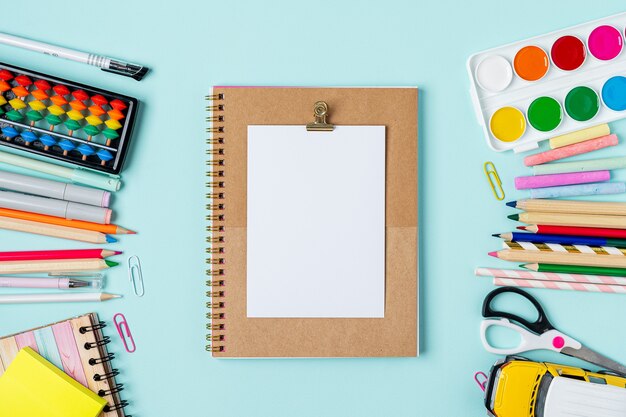 Flat lay of school supplies on table around empty space for text.