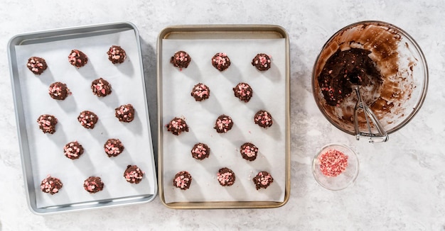 Flat lay Scooping chocolate cookie dough with dough scoop to bake chocolate cookies with peppermint chips