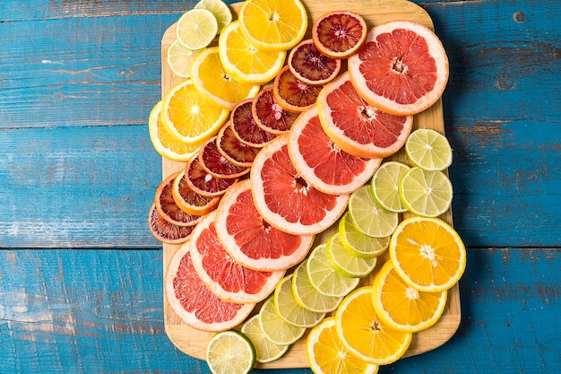 Photo flat lay slices of different raw fresh citrus fruit.