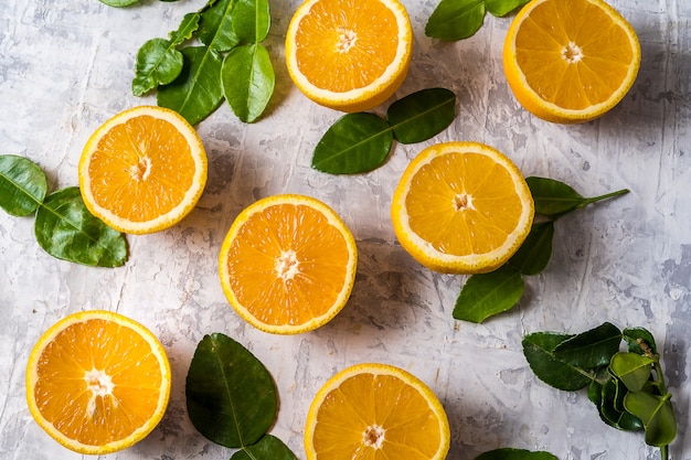 Flat lay slices of raw fresh orange fruit with leaves.