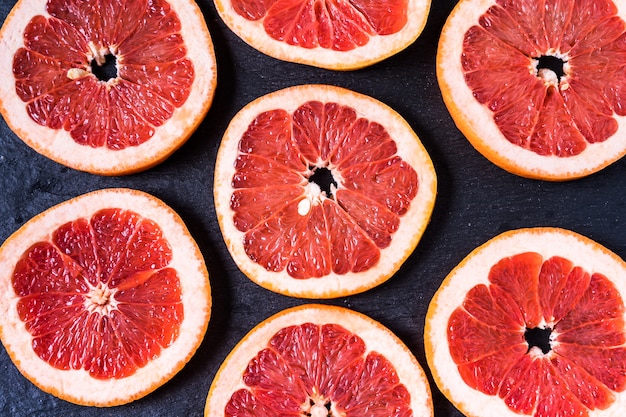 Photo flat lay slices of raw fresh red orange fruit.