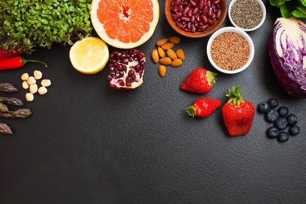 Flat lay of small amount of products for healthy diet. Set of fresh fruits and vegetables, nuts and berries for special healthy diet