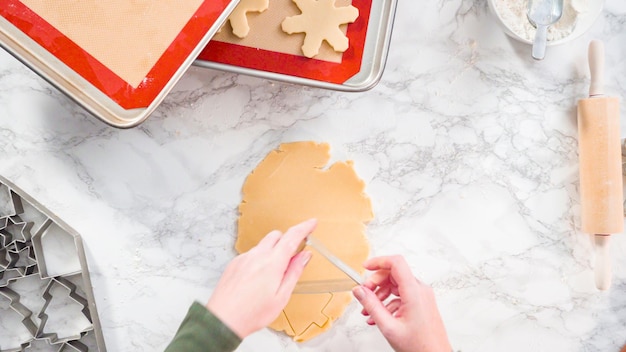 Flat lay. Step by step. Cutting out shapes with Christmas cookies cutter from sugar cookie dough.